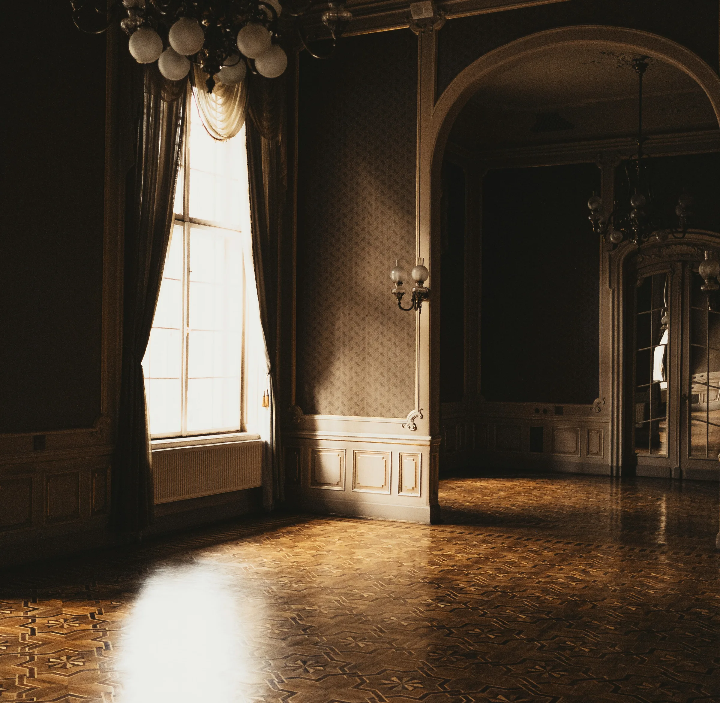 ÉPOQUE — Parisian heritage interior with chandelier and tall window